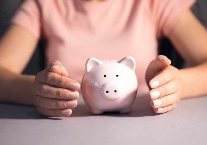 Women holding a piggy bank and coin